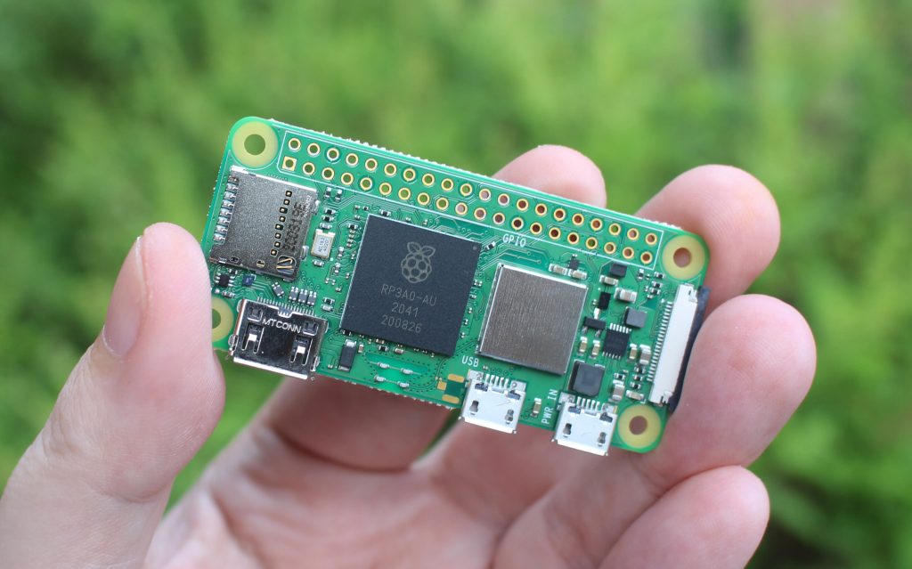 A Raspberry Pi Zero W single-board computer with a microSD card and mini HDMI to HDMI adapter